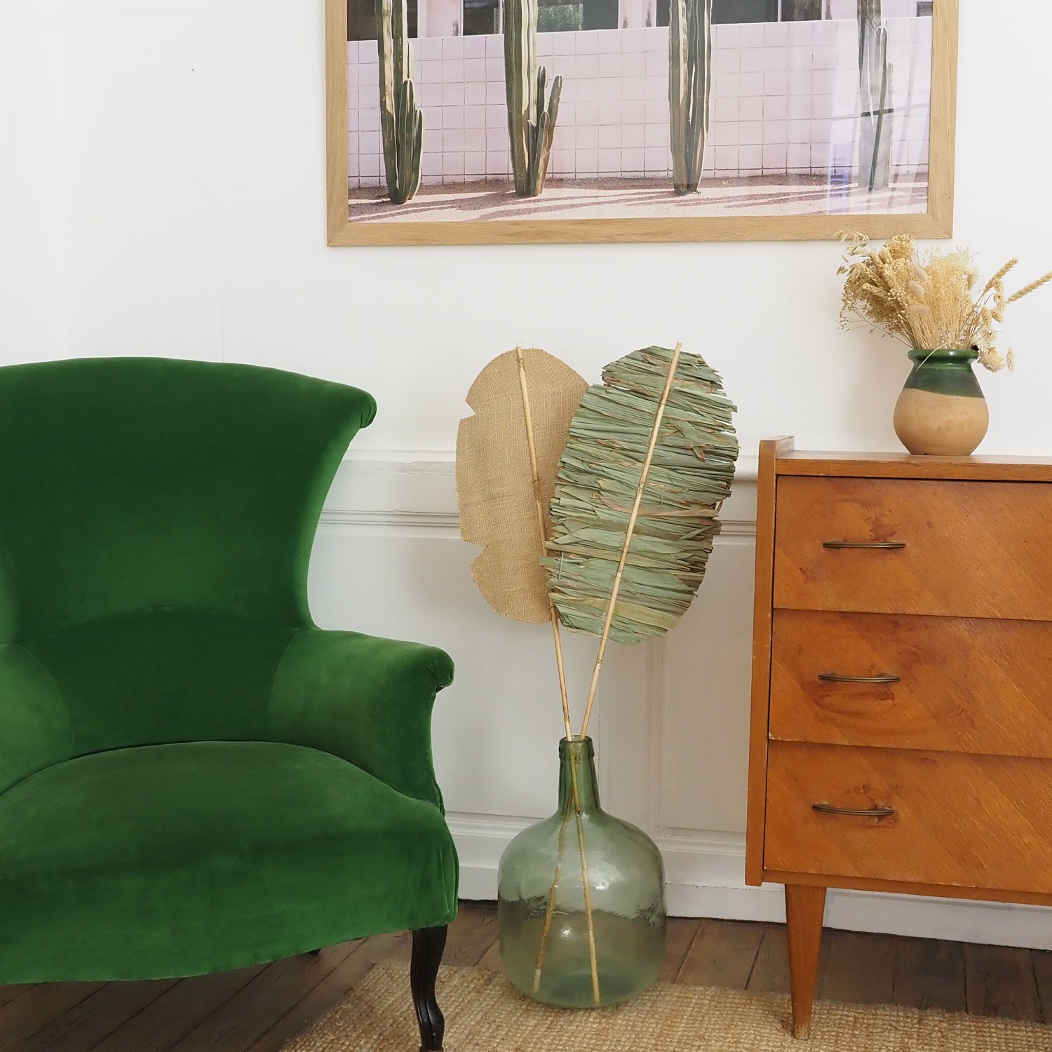 Feuille de palmier séchée indien 100cm dans un petit salon entre un fauteuil vert et une commode
