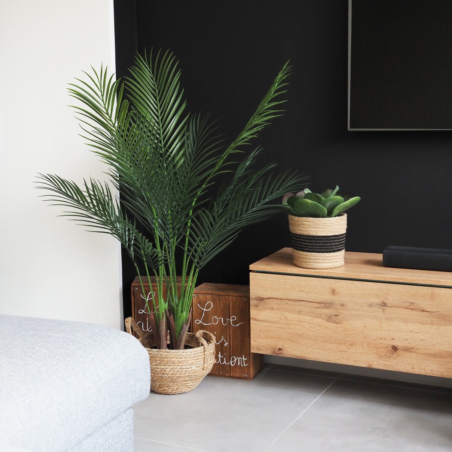 Succulente artificielle kalanchoe lucia 24cm en ambiance avec un palmier sur un meuble de télé