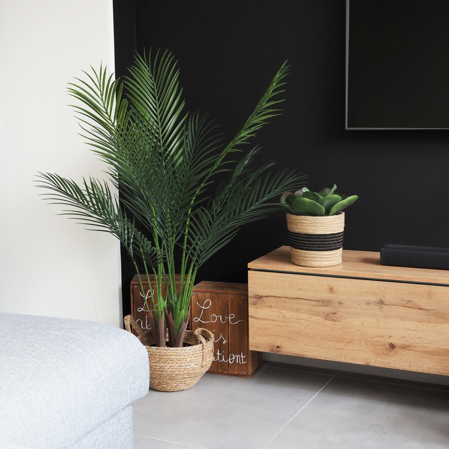Palmier artificiel areca 110cm en ambiance à côté du meuble télé avec une succulente et un cache-pot