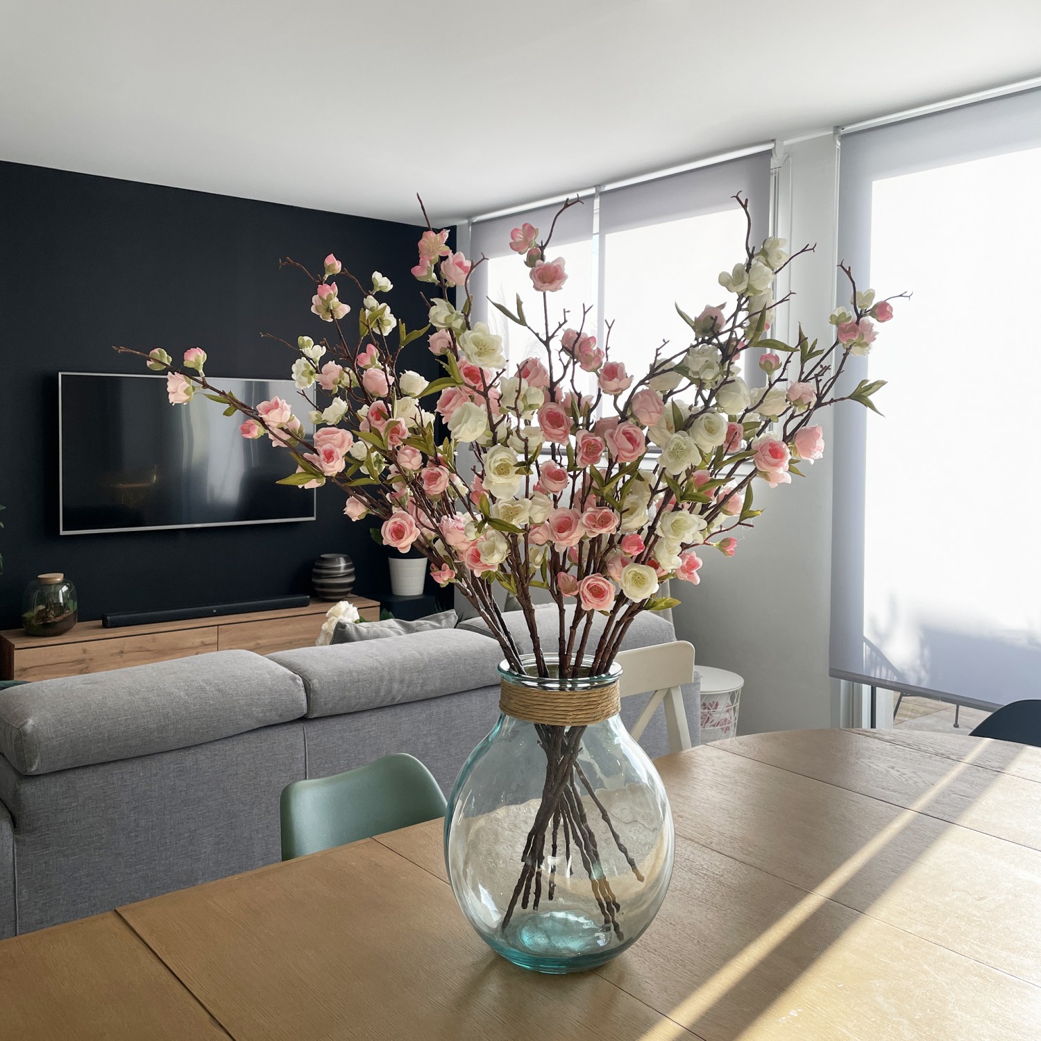 Branche artificielle cerisier 96cm lot de 12 en ambiance dans une dame jeanne posée sur la table à manger