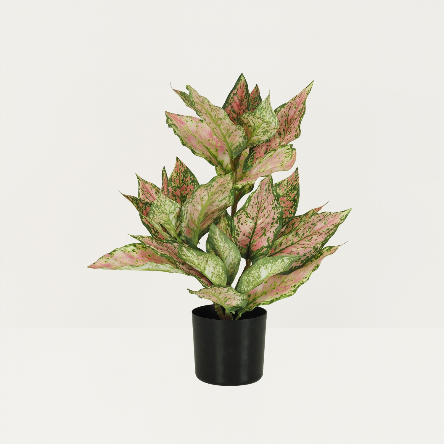 Croton artificiel rose 55cm sur fond beige