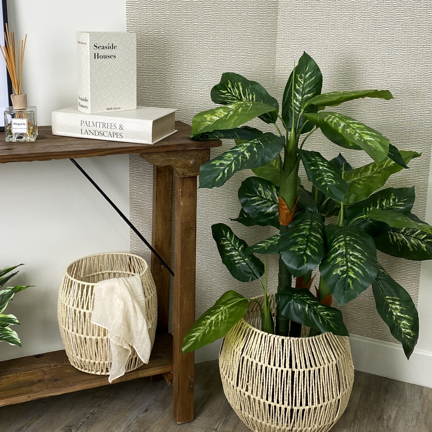 Dieffenbachia artificiel toucher naturel 130cm en ambiance dans un cache-pot à côté d'une console avec des éléments de déco