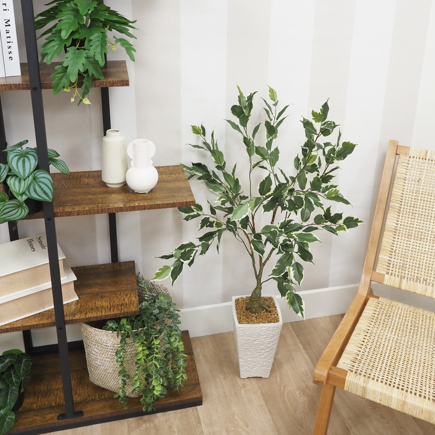 Ficus artificiel panaché 100cm posé à côté d'un canapé entre une bibliothèque et une chaise