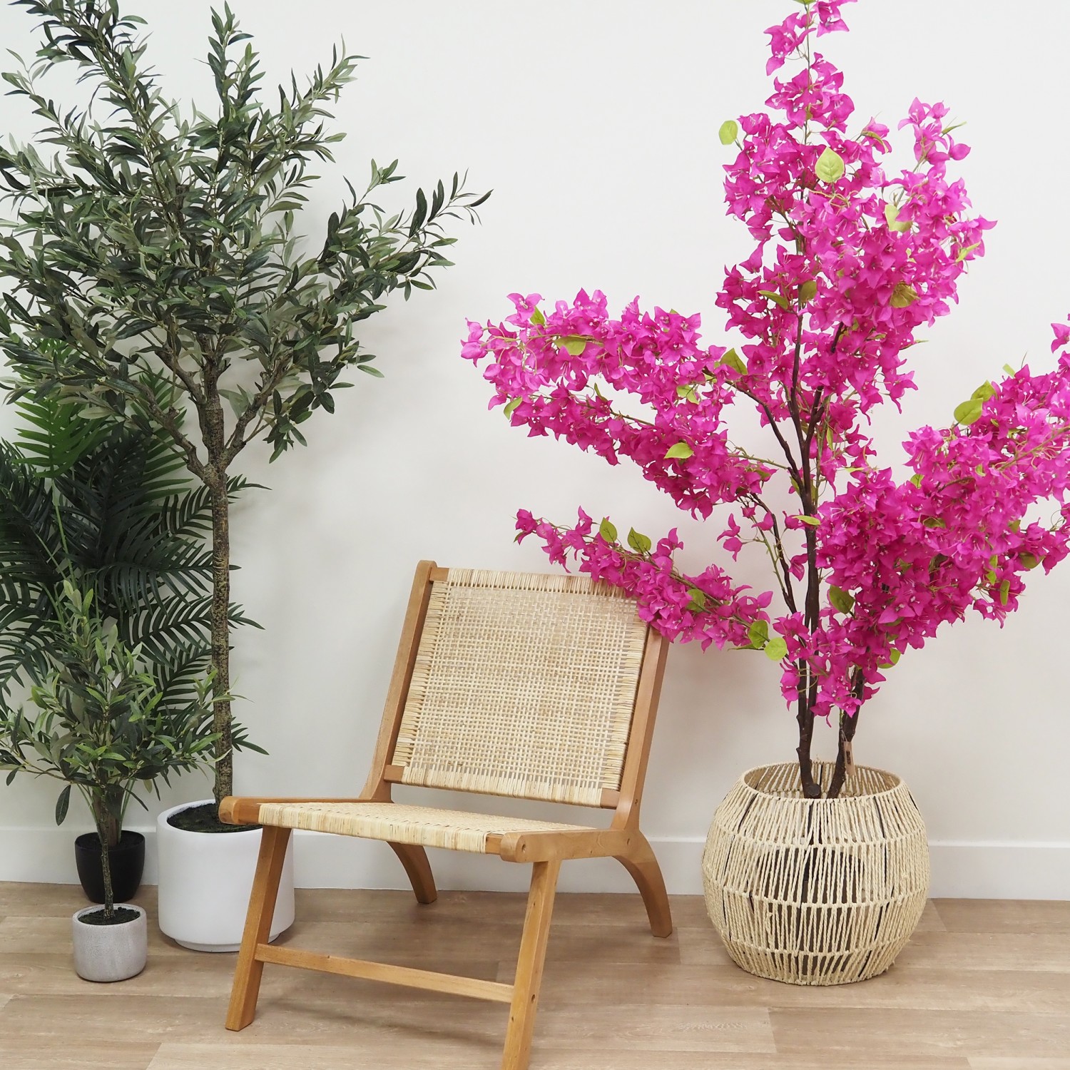 Bougainvillier artificiel fuchsia 175cm à côté d'un fauteuil dans un cache-pot