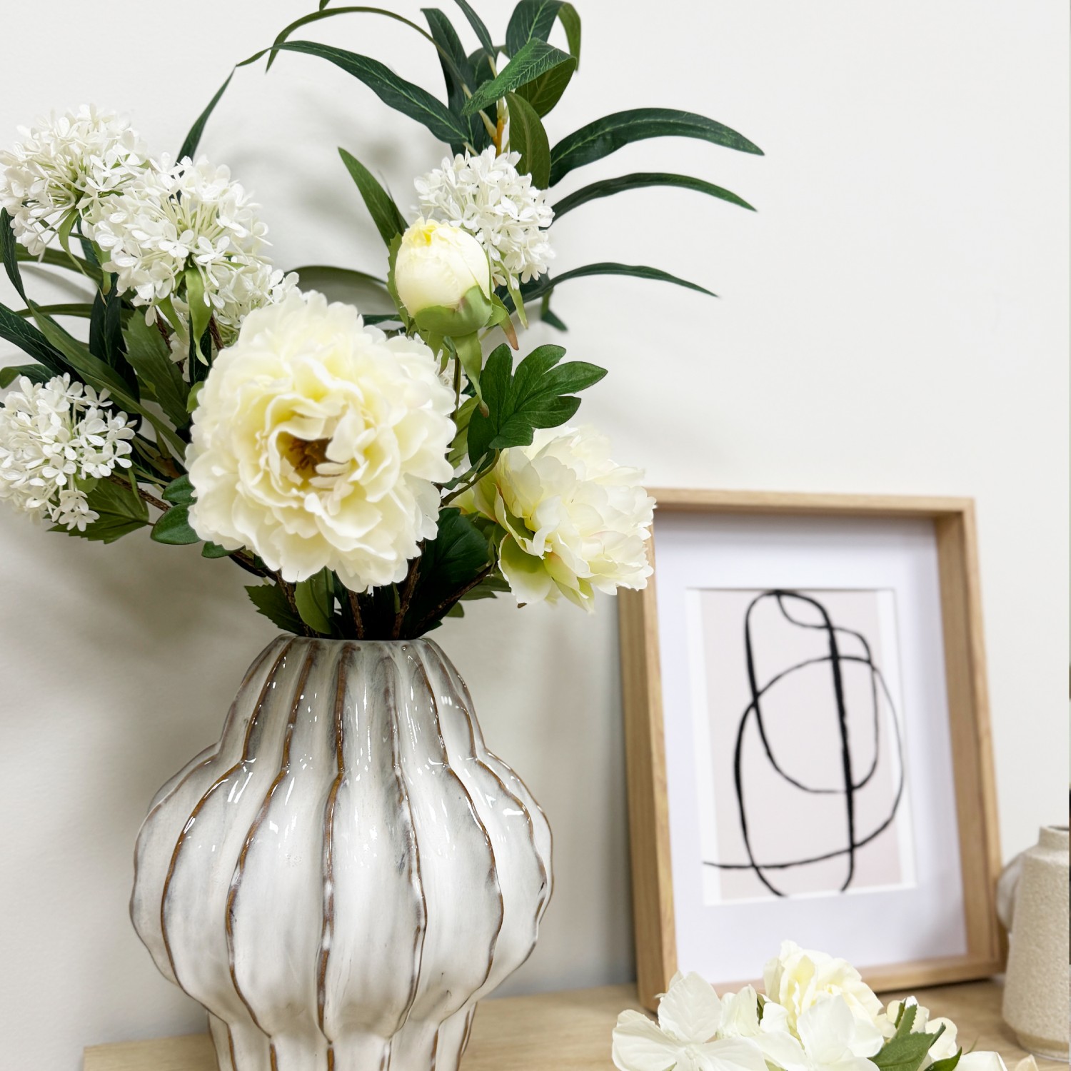 Pivoine artificielle en tige blanche 70cm lot de 4 dans un vase posé sur une commode