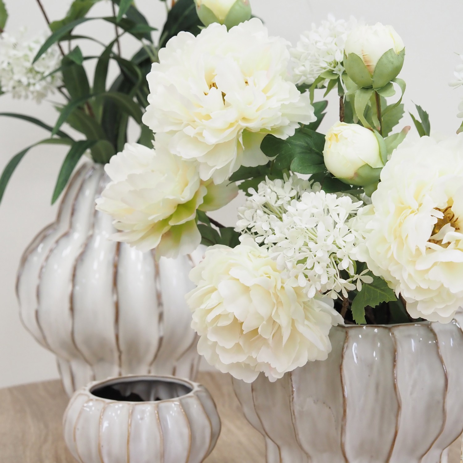 Pivoine artificielle en tige blanche 70cm lot de 4 dans un vase posé sur une table