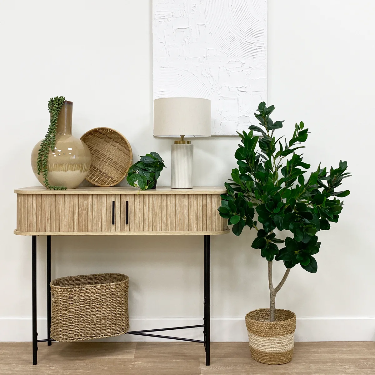 Laurier artificiel 328 feuilles 120cm posé à côté d'une console avec de la déco